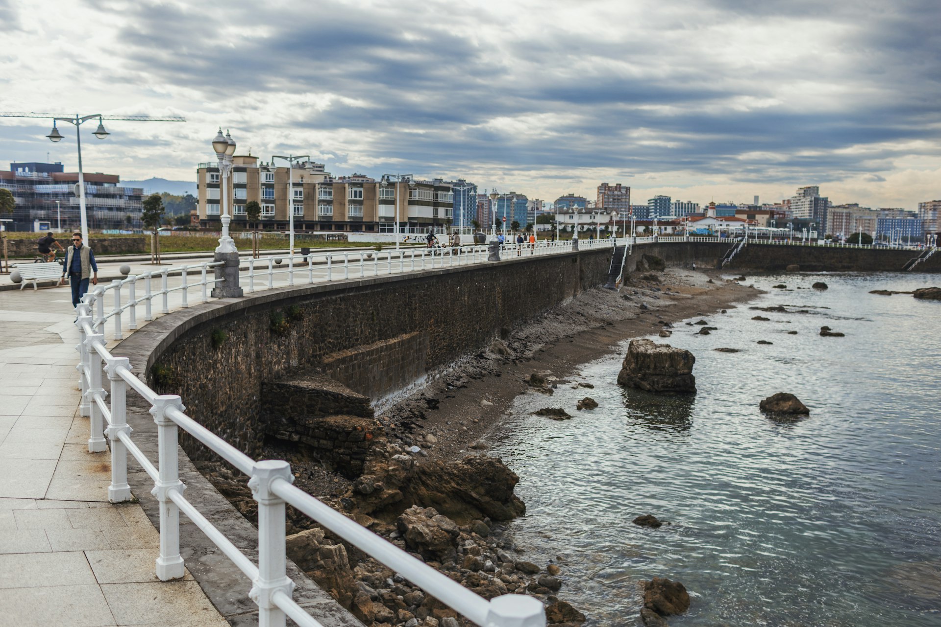 Seaside promenade with city buildings in background